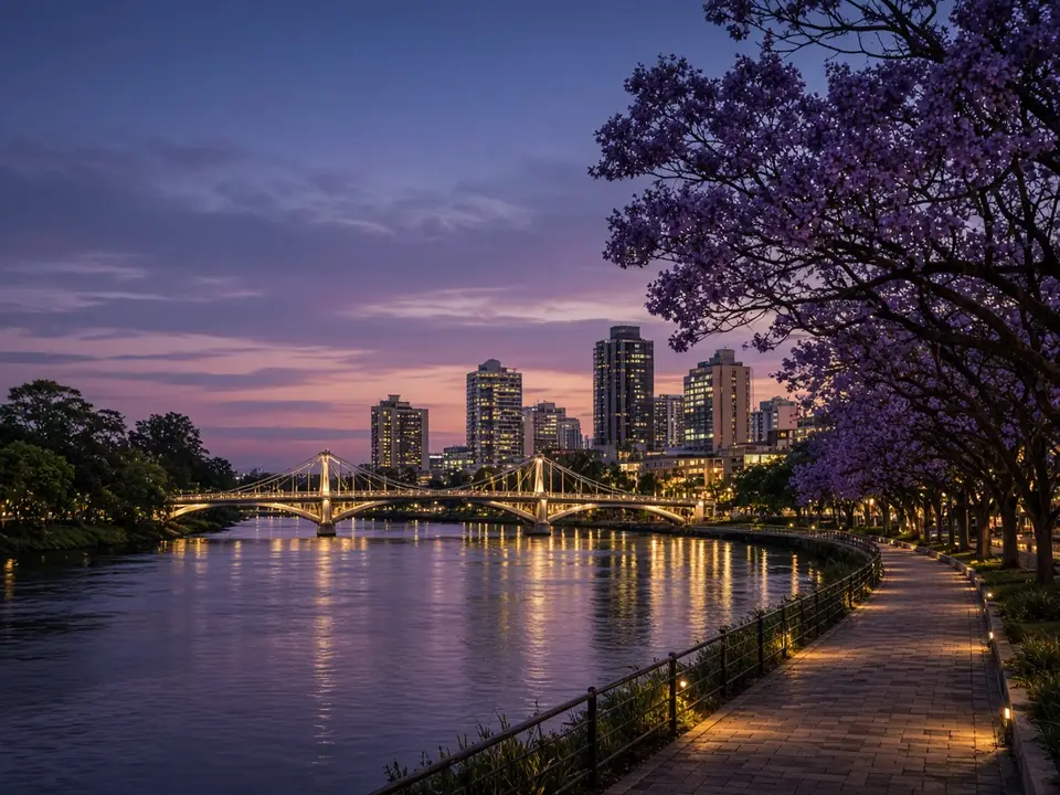 A riverside boardwalk at dusk under jacaranda trees
